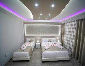 two beds in a room with purple lights at B&B La Rotonda - Il Dolce Relax in Santa Maria