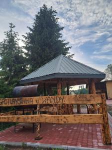 a wooden bench with writing on it in front of a pavilion at Noclegi u Wandy in Ropienka