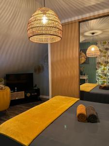 a bedroom with a bed with a yellow blanket and two lights at Chez Béa in Granville