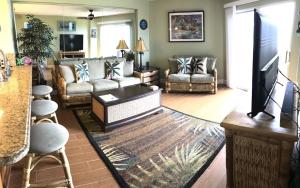 a living room with a couch and a tv at Tropical Daze Oceanfront Paradise in Tavernier