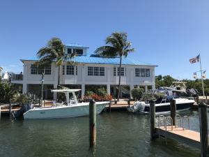 a boat docked in a marina in front of a house at Tropical Daze Oceanfront Paradise in Tavernier