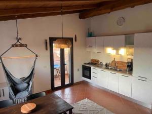 una cocina con una mesa y una hamaca. en Charming apartment with parking, mountain view, close to the beach, en Santa María