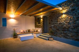 patio con panca e parete in pietra di Xerolithia suites a Agios Sostis Altre 21 foto