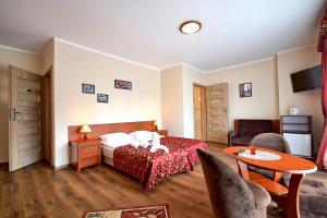 een hotelkamer met een bed en een tafel en stoelen bij VILLA DAIRA in Ustronie Morskie