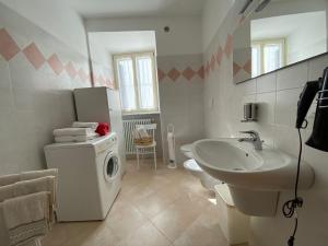 a bathroom with a sink and a washing machine at RESIDENZA LA CANONICA in Brez