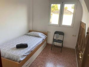 1 dormitorio pequeño con 1 cama y 1 silla en Casa Las Emilias en La Cañada, en Partida de La Cañada