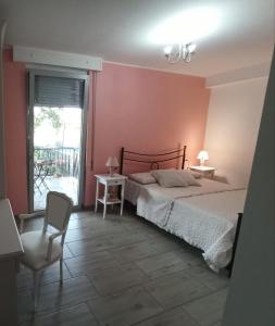 a bedroom with a bed and a chair and a window at B&B Villa Nora in Quartu SantʼElena