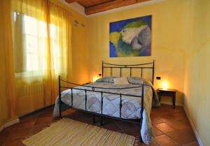 a bedroom with a bed and a painting on the wall at Cascina Il Convivio in Diano dʼAlba
