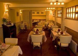 a restaurant with tables and chairs and a piano at Penzion Aurooms in Zlatníky +61 photos