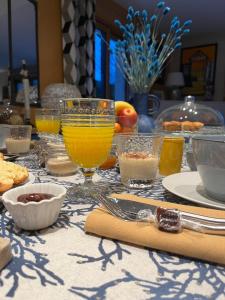 une table recouverte de verres de jus d'orange et d'autres aliments dans l'établissement Chez Béa, à Granville