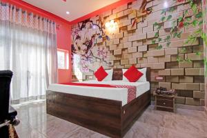 een slaapkamer met een bed en een bakstenen muur bij OYO Flagship Govind Residency in Greater Noida
