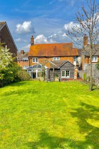 a house with a yard with a green lawn at Private Bedrooms in Quaint Oxfordshire Village Cottage in Wantage