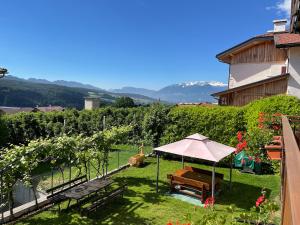 un jardín con mesa y sombrilla en RESIDENZA LA CANONICA, en Brez