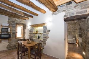 a living room with a table and a stone wall at Casa rural La Masadría in Mondot