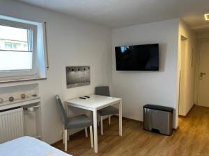 a room with a table and chairs and a television at *moderne Wohnung ANTON in VS mit Küche+Bad in Villingen-Schwenningen