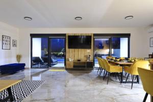 ein Wohnzimmer mit einem Esstisch und einem TV in der Unterkunft Villa Good Vibes with heated pool in Vrsi