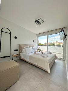 1 dormitorio con cama grande y ventana grande en Step One | Luxury Suites right in the heart of Acropolis next to metro station, en Atenas