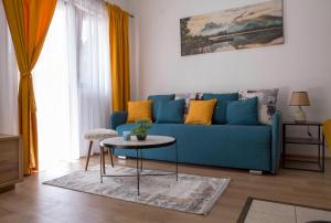 uma sala de estar com um sofá azul e uma mesa em Casa Del Durmitor em Žabljak