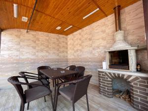 a patio with a table and chairs and a fireplace at Villa aeroport розовый дом in Chişinău