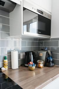 a kitchen counter with a coffee maker and a microwave at Design Suites Lytham in Lytham St Annes