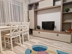 a living room with a television and a table and chairs at City Center Apartment in Bucharest