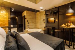 um quarto com uma cama grande e uma banheira em Medieval Motel SPA em Porto Alegre
