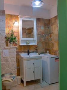 a bathroom with a sink and a toilet and a mirror at SWEET SMILE in Postira