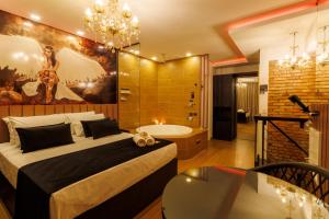 Medieval Motel SPA في بورتو أليغري: غرفة نوم بسرير كبير وحوض استحمام