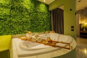 a bathroom with a tub with a green wall at Medieval Motel SPA in Porto Alegre