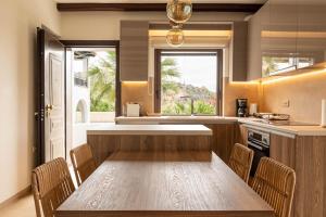 a kitchen with a wooden table and chairs at Angela's House by AegianKazarte in Kapótidhes