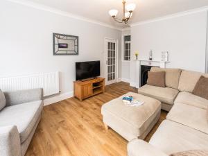 a living room with two couches and a tv at 2 Mount Pleasant in Looe