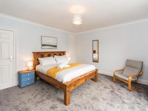 a bedroom with a bed and a chair at 2 Mount Pleasant in Looe