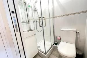 a white bathroom with a shower and a toilet at Coeur Massy M7 Rer BC 600m - Orly20 min in Massy