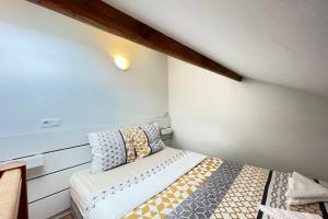 um pequeno quarto com uma cama com almofadas em Coeur Massy M7 Rer BC 600m - Orly20 min em Massy