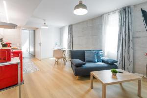 een woonkamer met een blauwe bank en een tafel bij Easy flat Vezia, indipendent entrance, free parking in Lugano