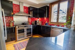 a kitchen with black cabinets and red tiles at Les Grands Montets Family Lodge in Chamonix