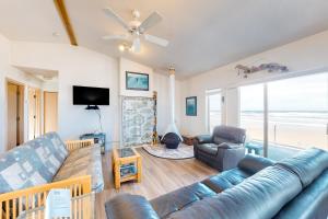 a living room with a couch and a television at Sandy Shores in Yachats