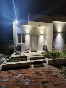 una casa blanca con 2 sillas y una puerta en StoneSide Villa, en Providenciales