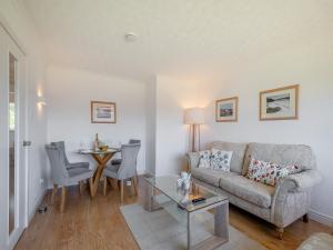 a living room with a couch and a table at Seamill Cottage in Seamill