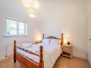 Un dormitorio con una cama grande y una ventana en Seamill Cottage, en Seamill