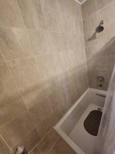 StoneSide Villa في بروفيدنسياليس: حمام مع دش مع حوض استحمام