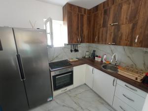 a kitchen with wooden cabinets and a stainless steel refrigerator at House with pool - Mitrovic in Herceg-Novi
