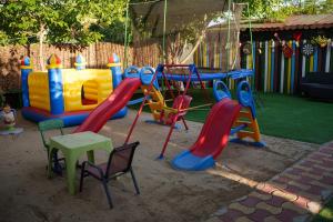 un parque infantil con tobogán, mesa y sillas en Casa Nita en Corbu