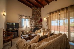 a living room with a couch and a tv at Agnadia Villa in Stalos