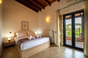 a bedroom with a bed and a large window at Agnadia Villa in Stalos
