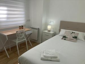 - une chambre avec un lit, un bureau, une table et une chaise dans l'établissement Magnífico piso con gran terraza en centro de Vigo, à Vigo