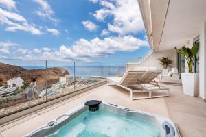 een hot tub in een kamer met uitzicht op de oceaan bij Grand Horizon Luxury Boutique Apartments in Puerto Rico de Gran Canaria