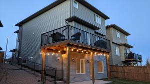 a house with a balcony with lights on it at Kid & Pet Friendly Walkout BSMT 90 mins to Banff and 30 mins to Downtown Calgary in Calgary