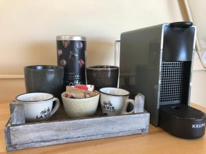 a tray with cups and coffee cups on a table at Cerchio Del Desiderio Glamping Retreat in Pescara