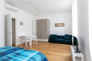 a bedroom with a blue couch and a table at ~ Cozy Apartment ~ City Center [Train Station] in Trieste